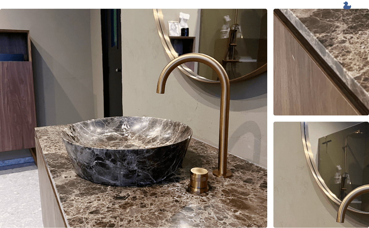 Marmorwaschbecken mit goldenem Wasserhahn, luxuriöser Marmorarbeitsplatte und rundem Spiegel.